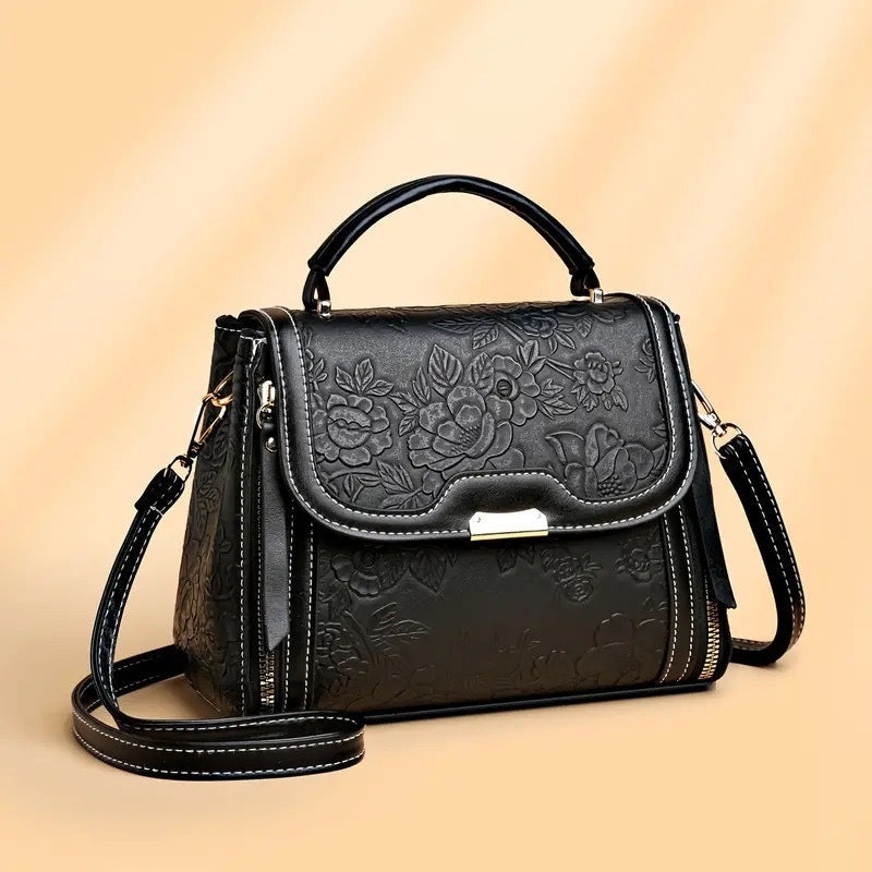 Simple black shoulder messenger bag with floral engravings, soft PU material, and single strap.