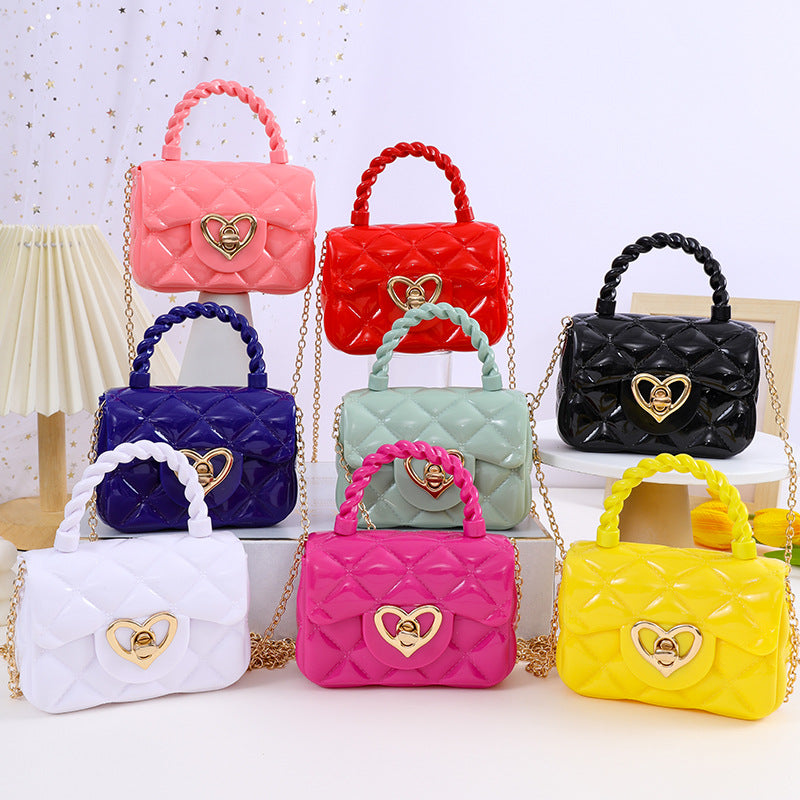 Plastic transparent jelly mini love handbags in various colors on display.
