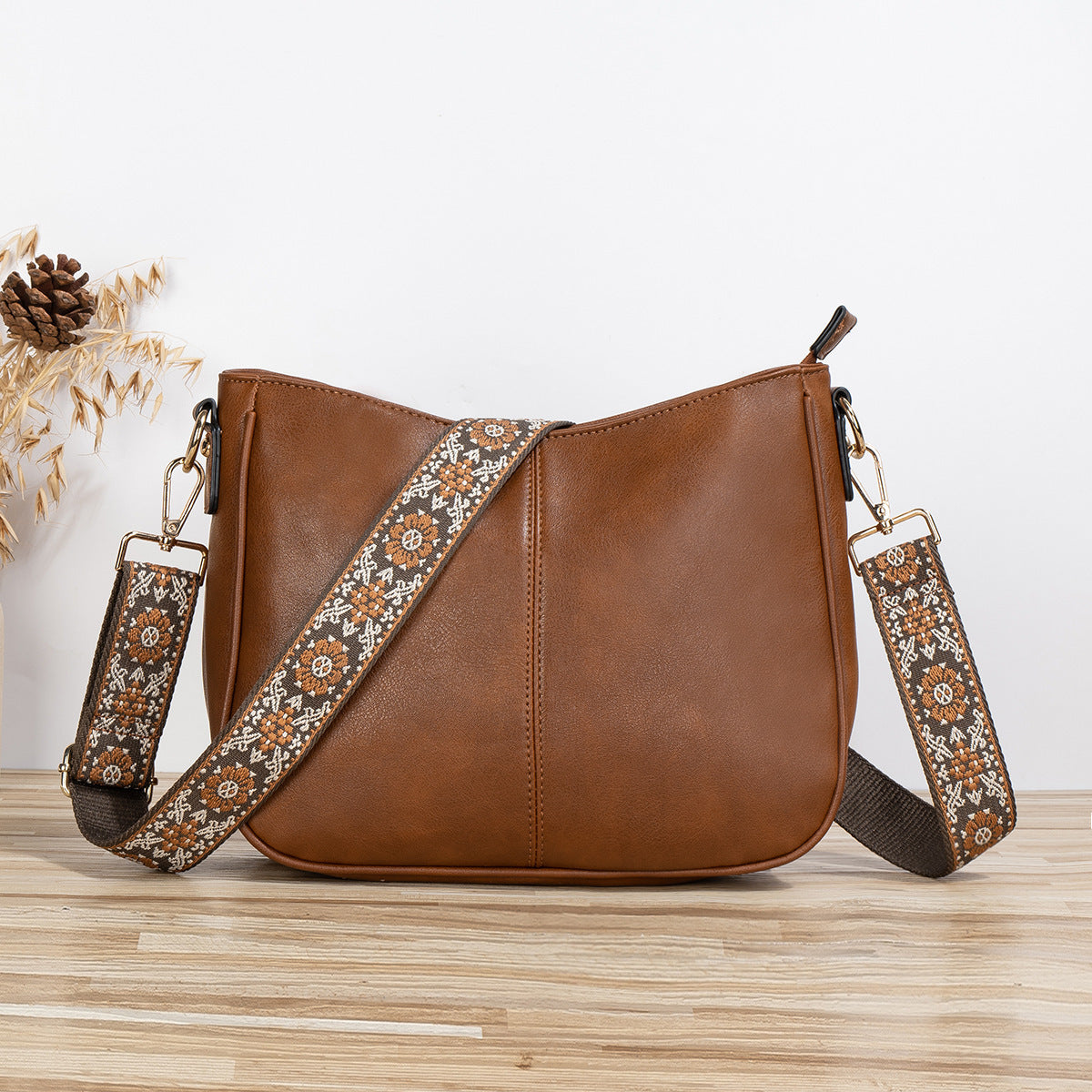 Simple fashion crossbody shoulder bag in brown PU leather with floral strap.