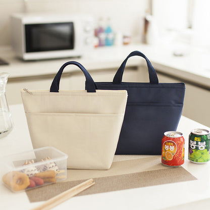 Portable waterproof bento Oxford lunch bags in beige and dark blue on a kitchen counter.