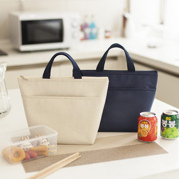 Portable waterproof bento Oxford lunch bags in beige and dark blue on a kitchen counter.