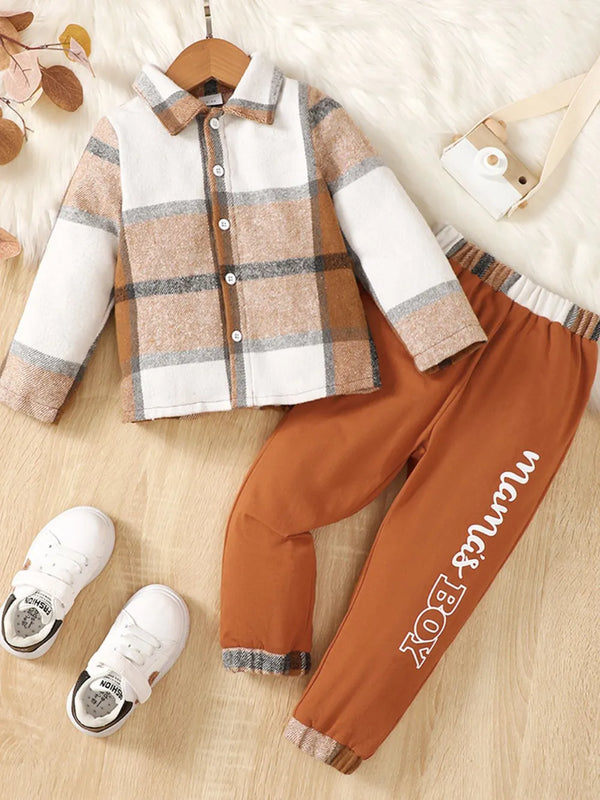 Toddler color block button up top and rust-colored pants set with white sneakers and toy camera.