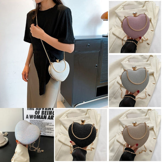 Heart-shaped evening clutch bag with a metal chain, available in pink, gold, black, silver, and white. Fashionable design for Valentine's Day.