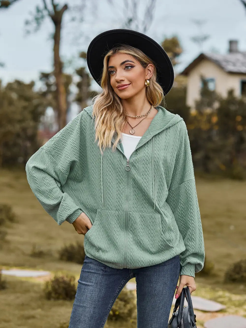 woman wearing green zip up drawstring long sleeve hooded jacket outdoors