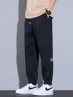 Men's plus size loose fit black jeans with drawstring and pockets, slightly stretchy polyester fabric.