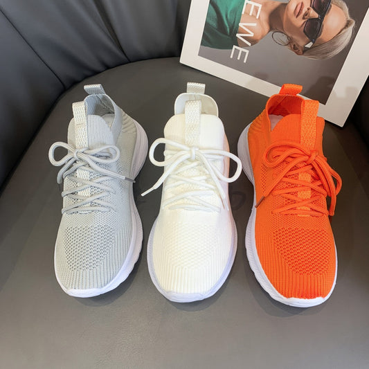 Women's fashionable mesh breathable running shoes in gray, milky white, and orange on display.