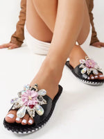 black floral embellished slide sandals with rhinestone and pink flower decoration on model feet