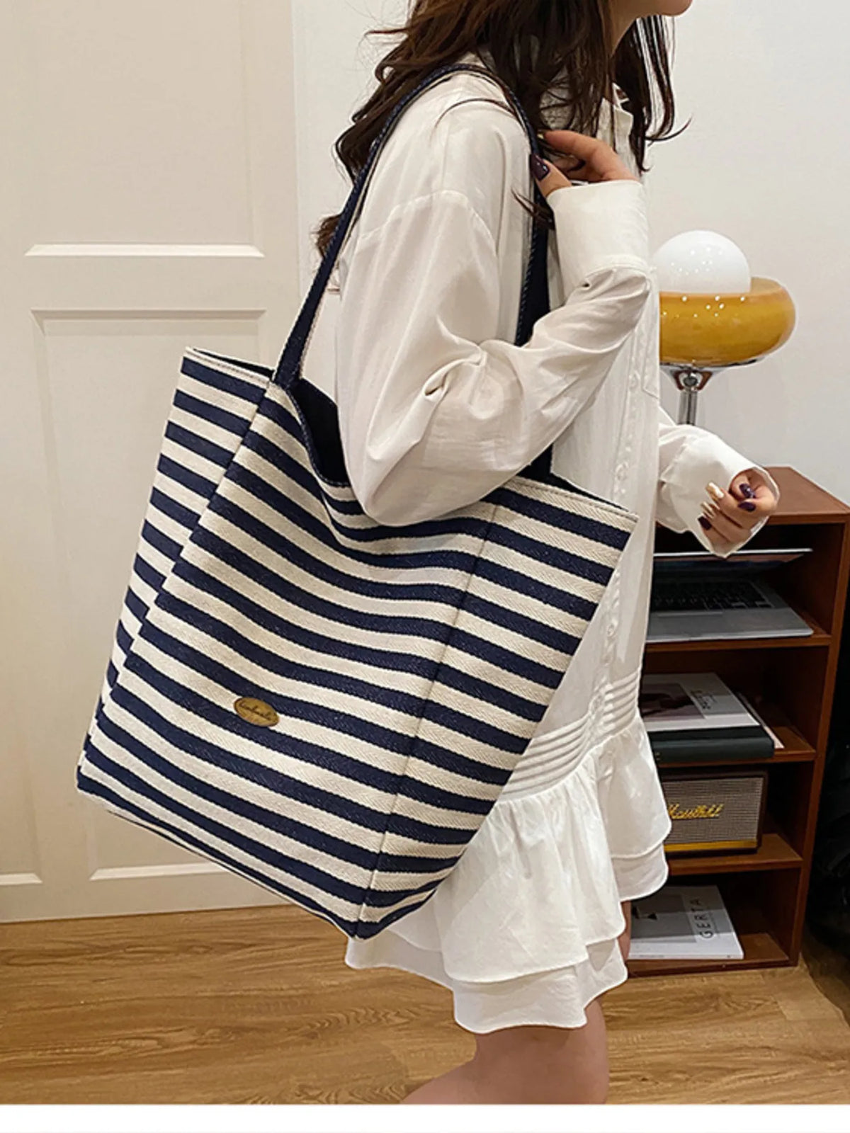 Large striped canvas tote bag with navy and white horizontal stripes and long handles.