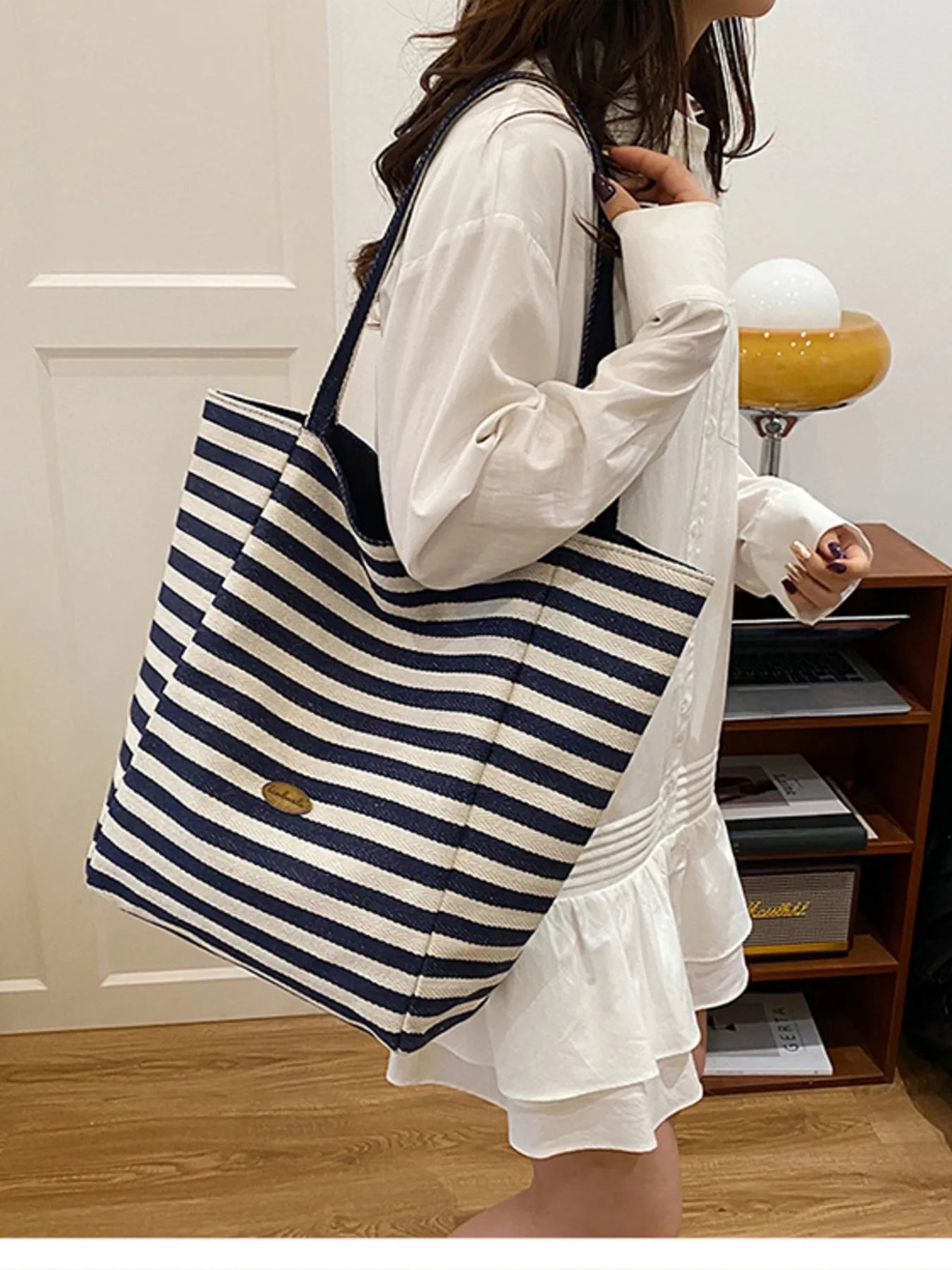 Large striped canvas tote bag with navy and white horizontal stripes and long handles.