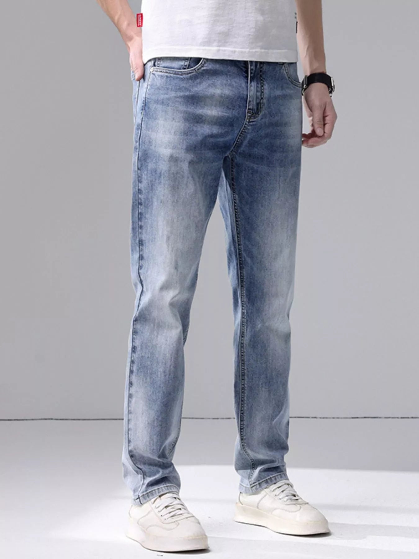 Men's washed slim fit jeans with cat's whisker detailing and slight stretch in light blue denim