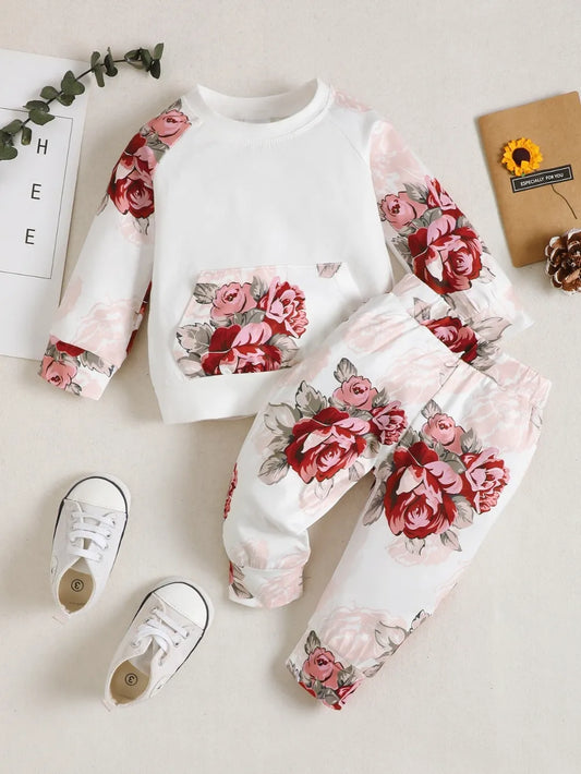 Children's two-piece floral top and pants set with pocketed design in white and pink rose pattern, made of polyester and elastane.