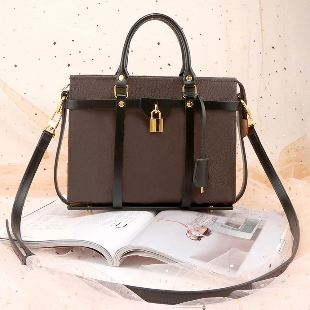 Leather Shell Single Shoulder Crossbody bag with wide leather straps, displayed with elegant design and gold accents.