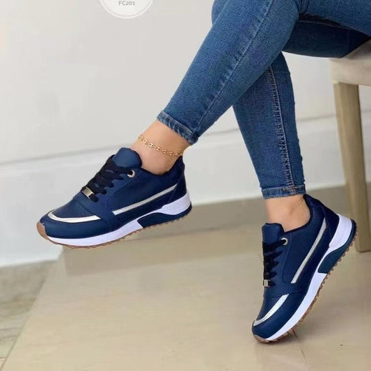 Casual lace-up flat shoes for women with blue colorblocking and sequins, round toe, and rubber sole, worn with jeans.