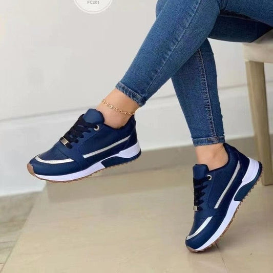 Casual lace-up flat shoes for women with blue colorblocking and sequins, round toe, and rubber sole, worn with jeans.