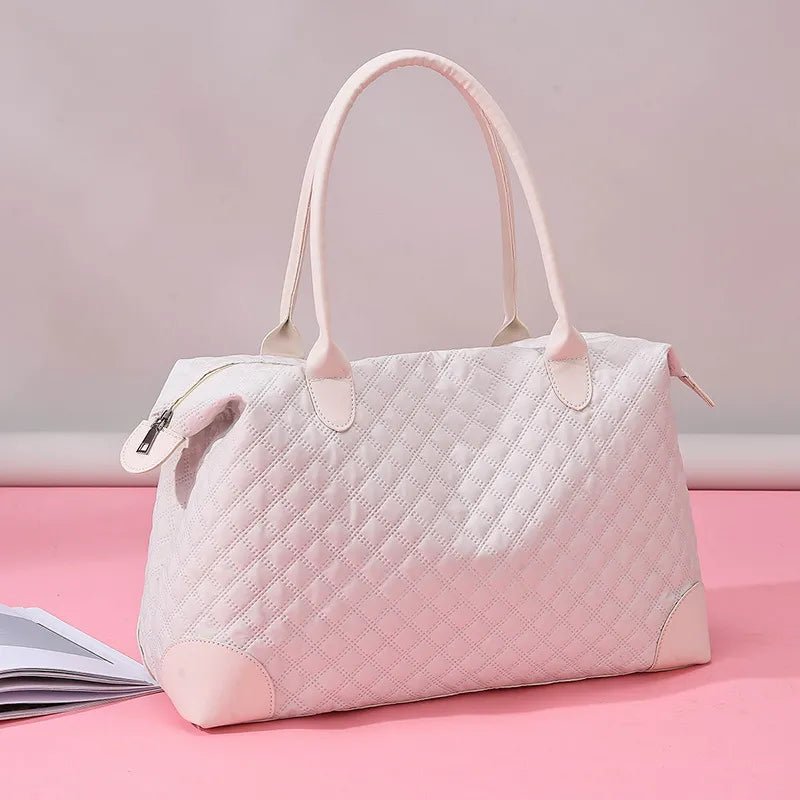 Large Oxford travel bag in light pink quilted Oxford cloth with dual handles and zipper closure on pink background