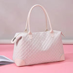 Large Oxford travel bag in light pink quilted Oxford cloth with dual handles and zipper closure on pink background