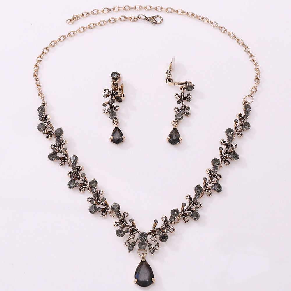 Bridal rhinestone zircon necklace and earring set with intricate design in antique gold.