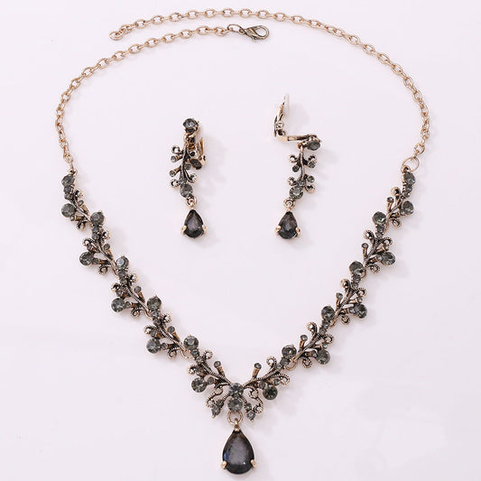 Bridal rhinestone zircon necklace and earring set with intricate design in antique gold.