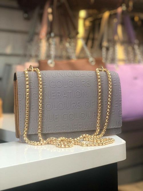 Grey mini shoulder bag with gold chain strap and embossed text design