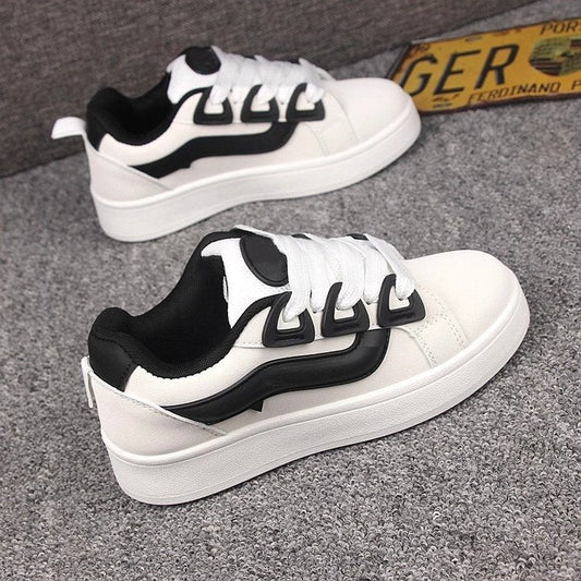 Women's casual platform sneakers in white and black, featuring mid heel, rubber sole, and lace-up design.