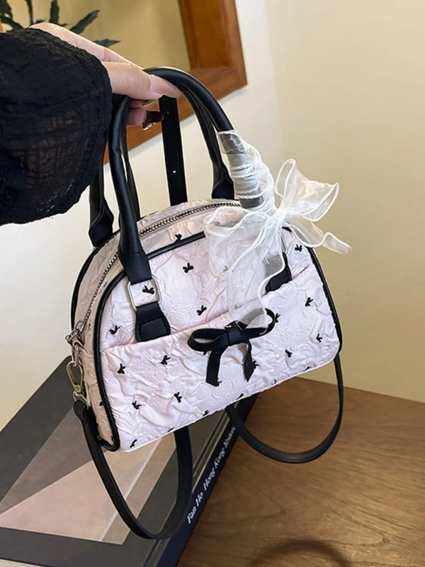 Small ruched bow crossbody bag in pink PU leather with black handles and floral detailing