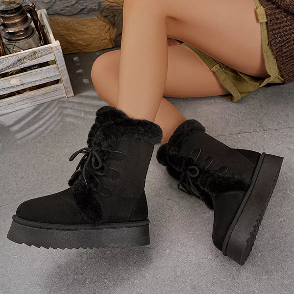 Black round toe platform boots with fluff lining and mid heels on model's feet