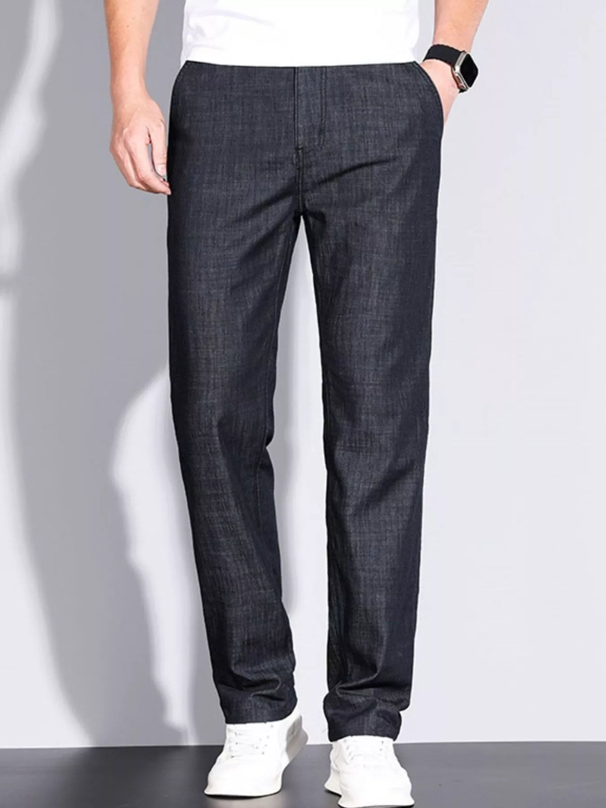 Men's dark-colored straight leg jeans with slight stretch and pockets, styled for a basic look.