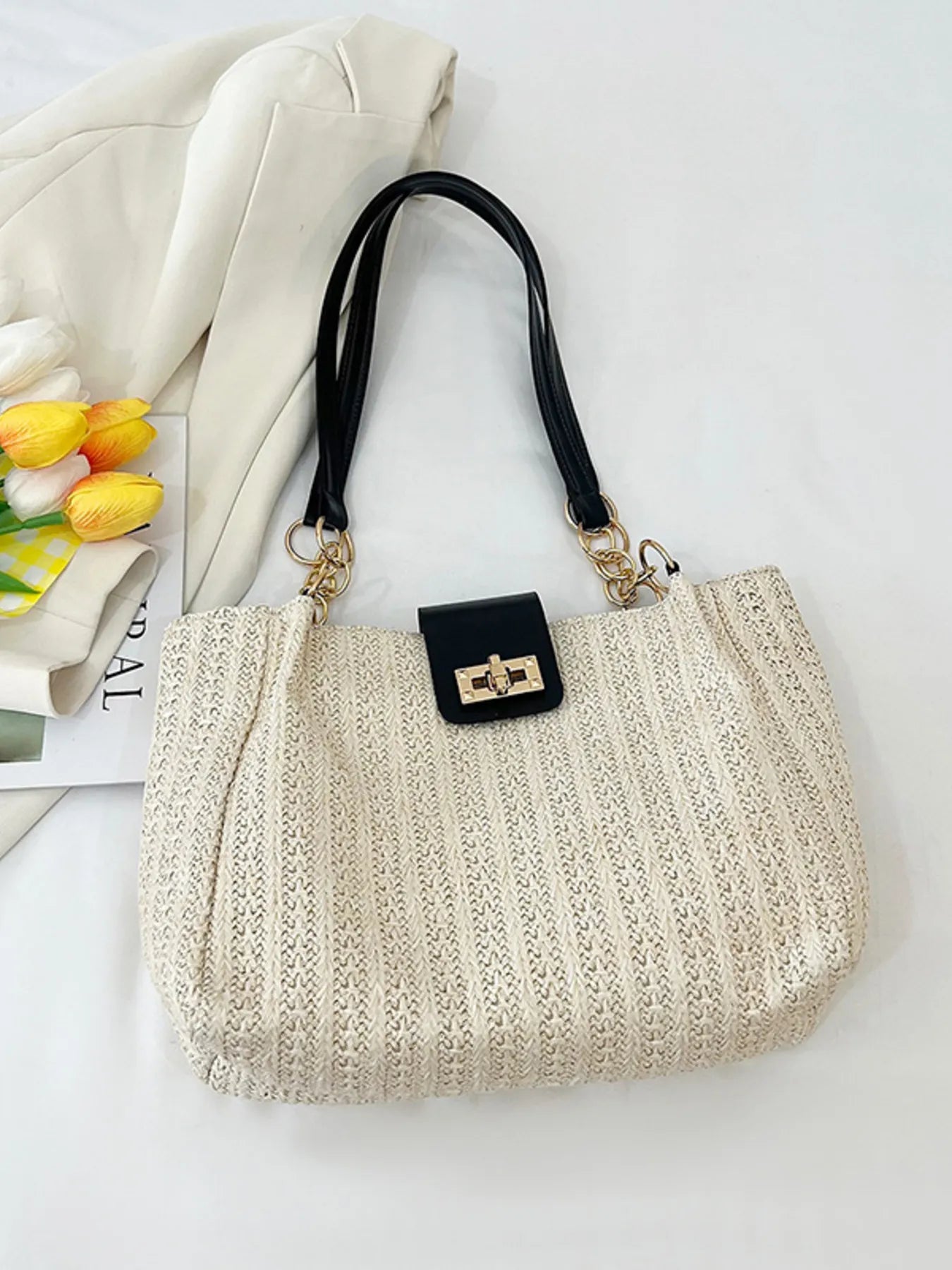 Woven straw shoulder bag medium size with black handles and gold-tone clasp, made of PU leather, polyester, and straw.
