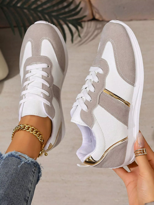 Round toe lace up sneakers in white and gray PU leather with low heels and rubber soles.