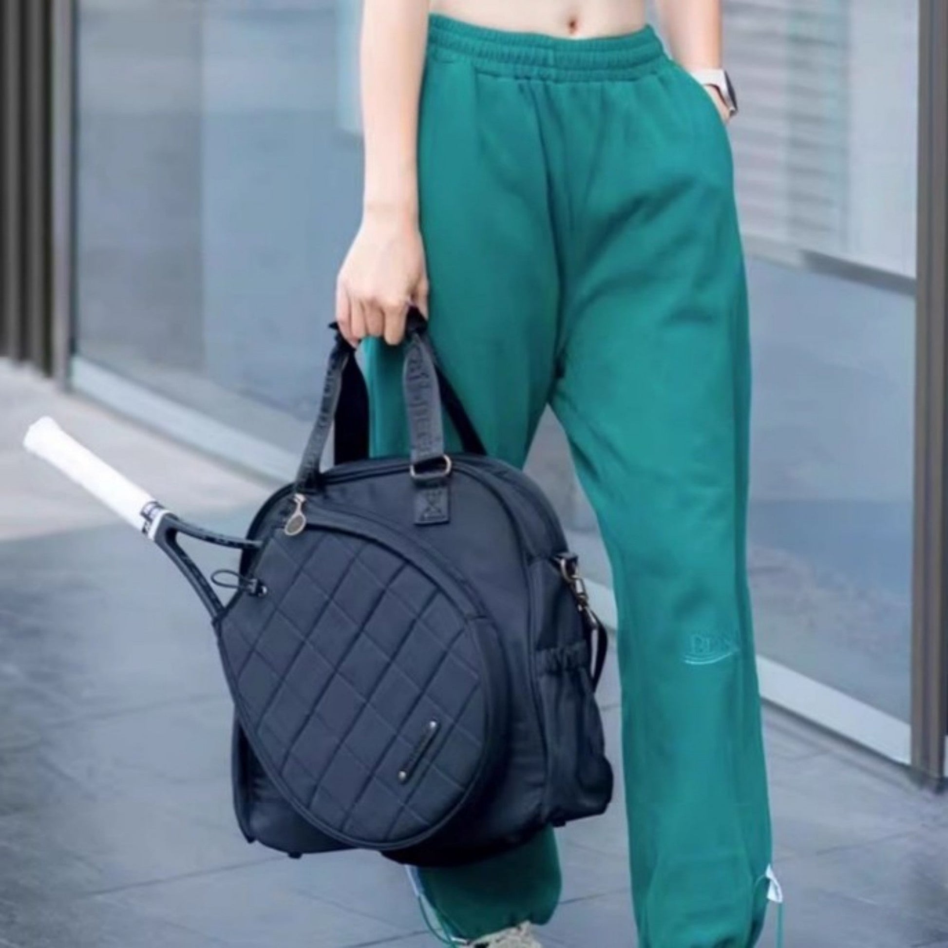 Tennis and badminton bag set carried by person in casual attire.