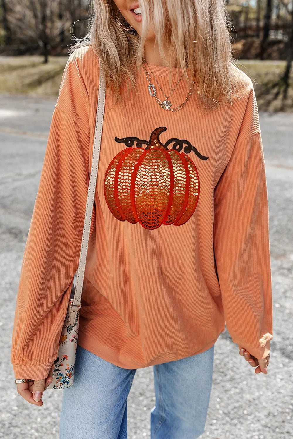 Orange long sleeve sweatshirt with sequin pumpkin design and round neck