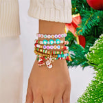 Christmas beaded bracelet set with colorful beads, holiday charms, and festive design on wrist near Christmas tree