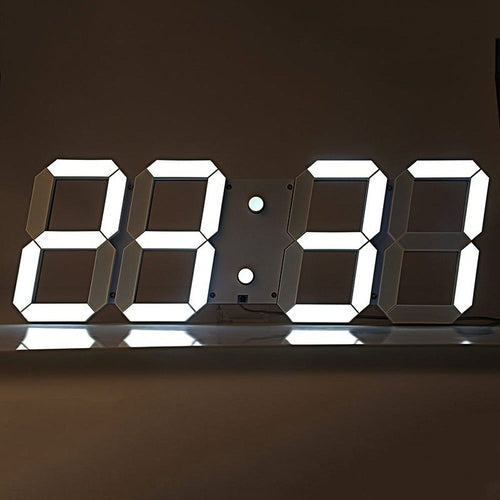 Digital LED wall clock with large bright white digits displaying time in 24-hour format on a dark background