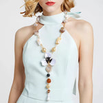 Woman wearing 18K gold-plated alloy dripping oil flower resin Y-shaped necklace with decorative beads and flower pendant