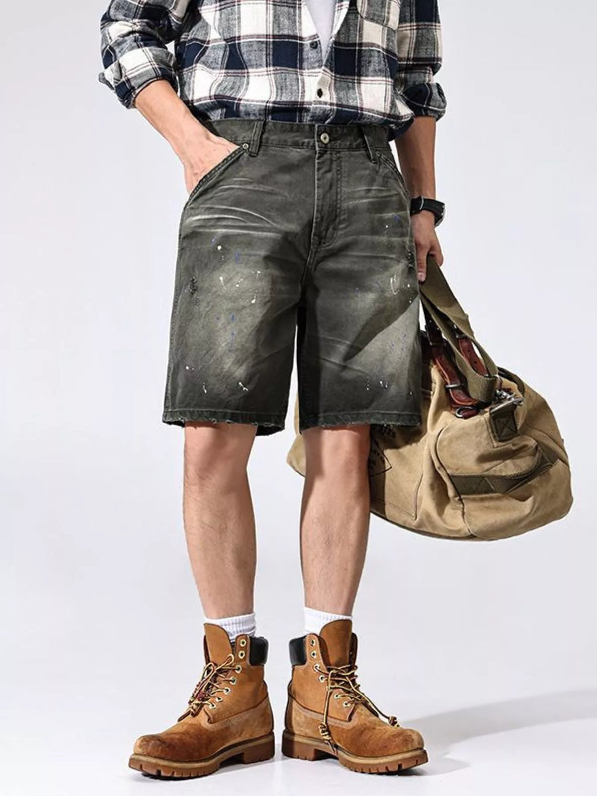Men's loose fit distressed cotton shorts with pockets, styled with plaid shirt and boots