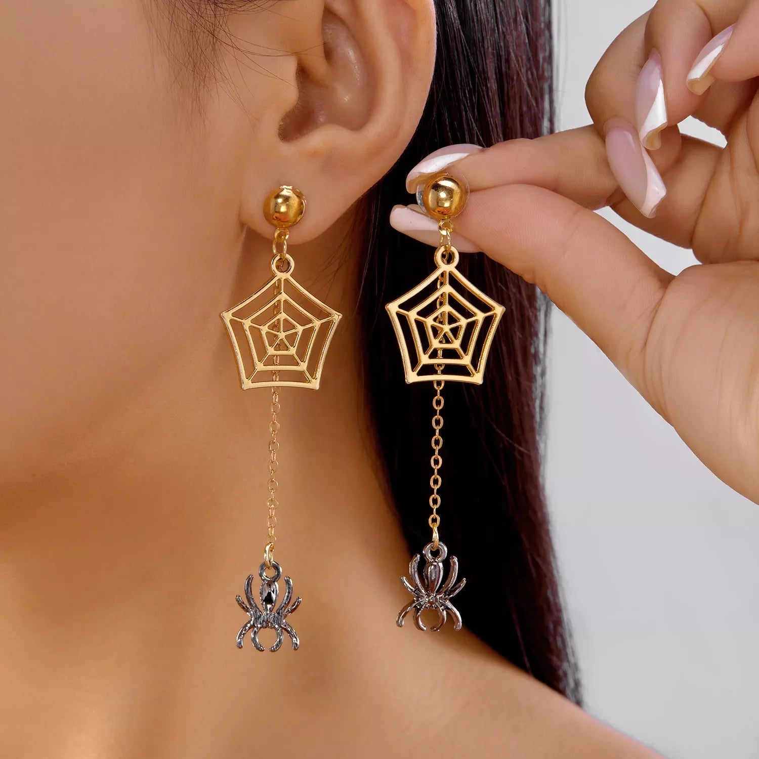 18K gold-plated spider drop earrings with web design and hanging spider charm on model
