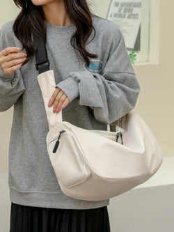 Large Oxford cloth crossbody bag in beige with multiple zippered compartments worn over shoulder